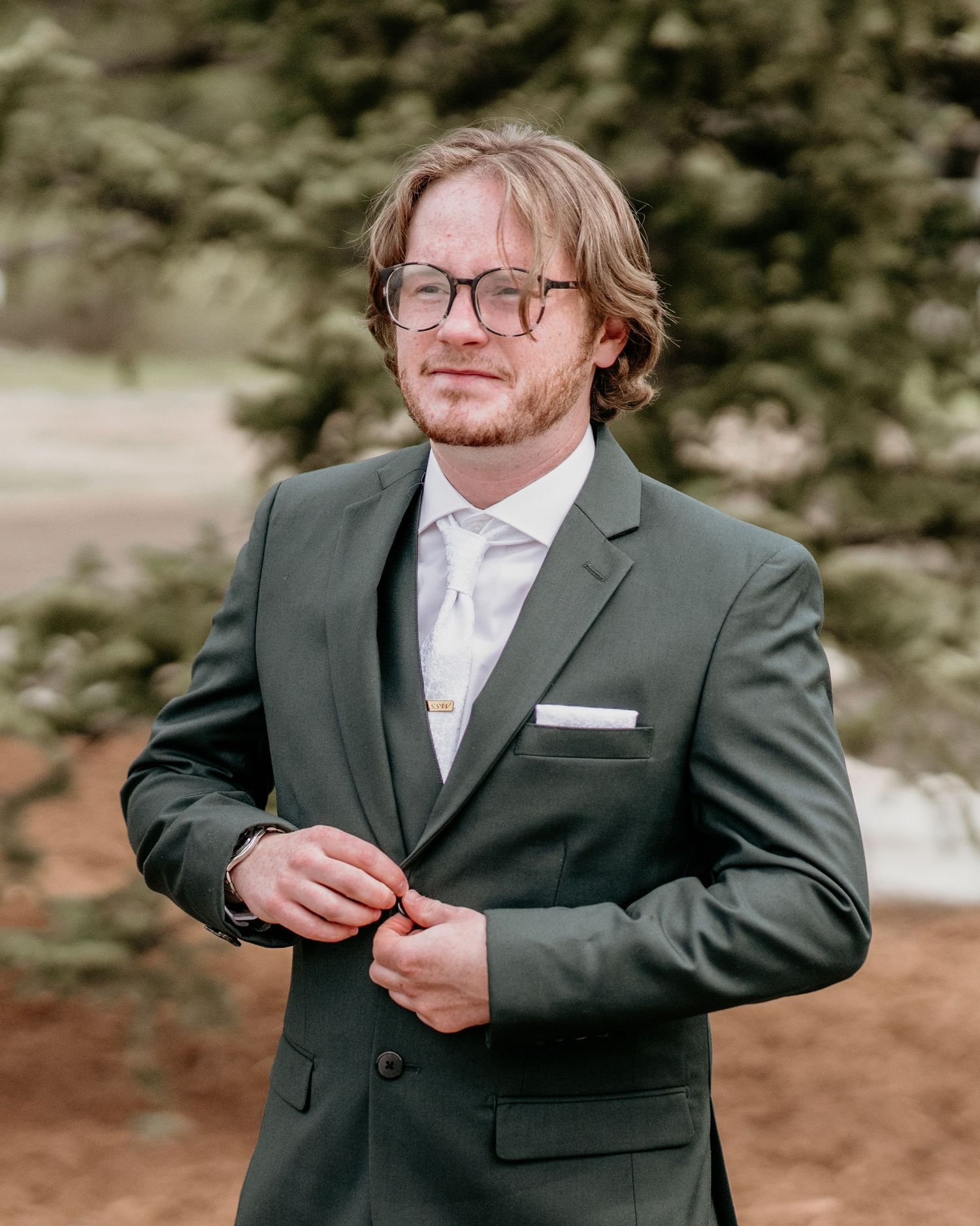 Formal portrait in gray suit with glasses and white tie. groom