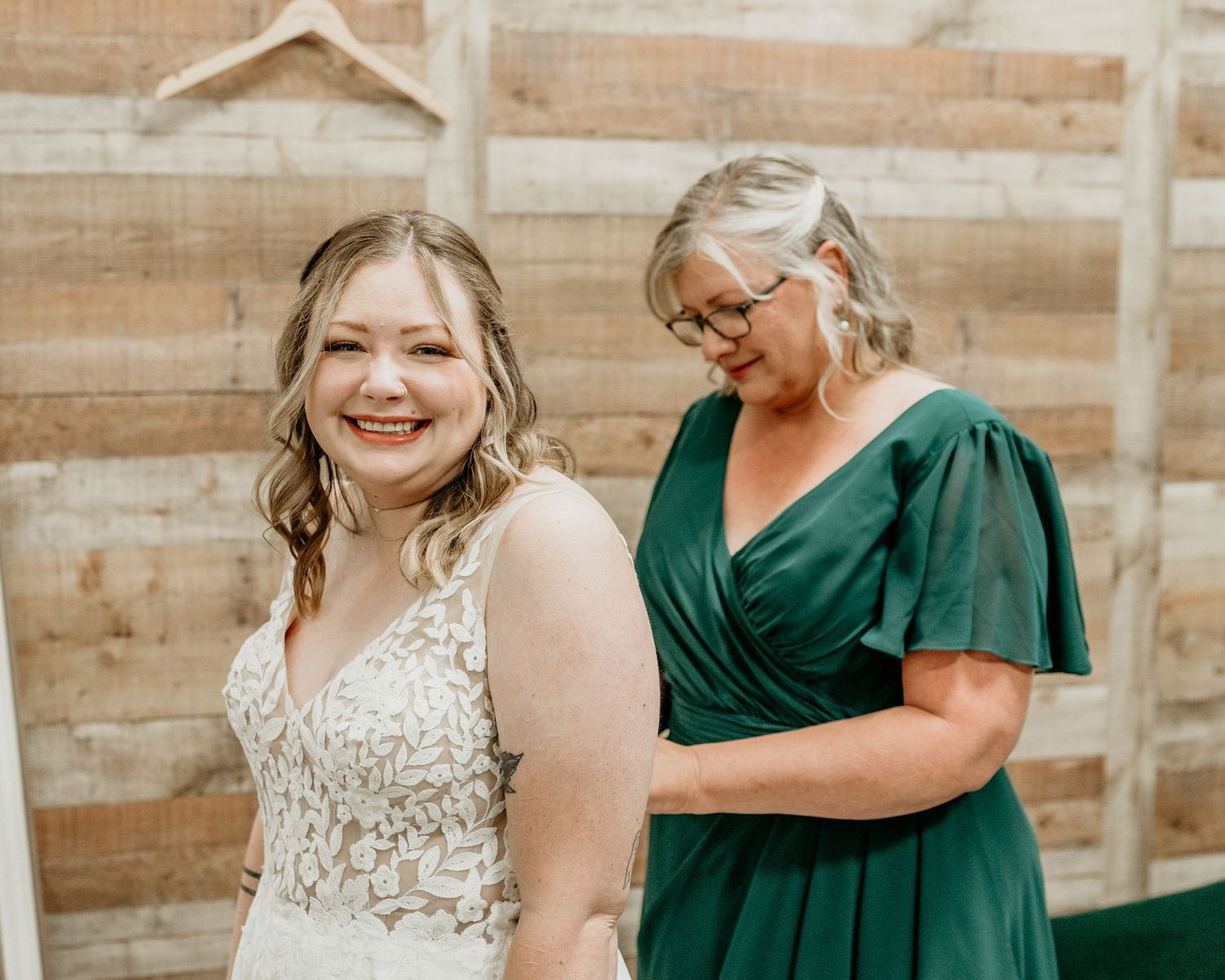 Getting ready moment in white lace dress with emerald green accent. mother daughter