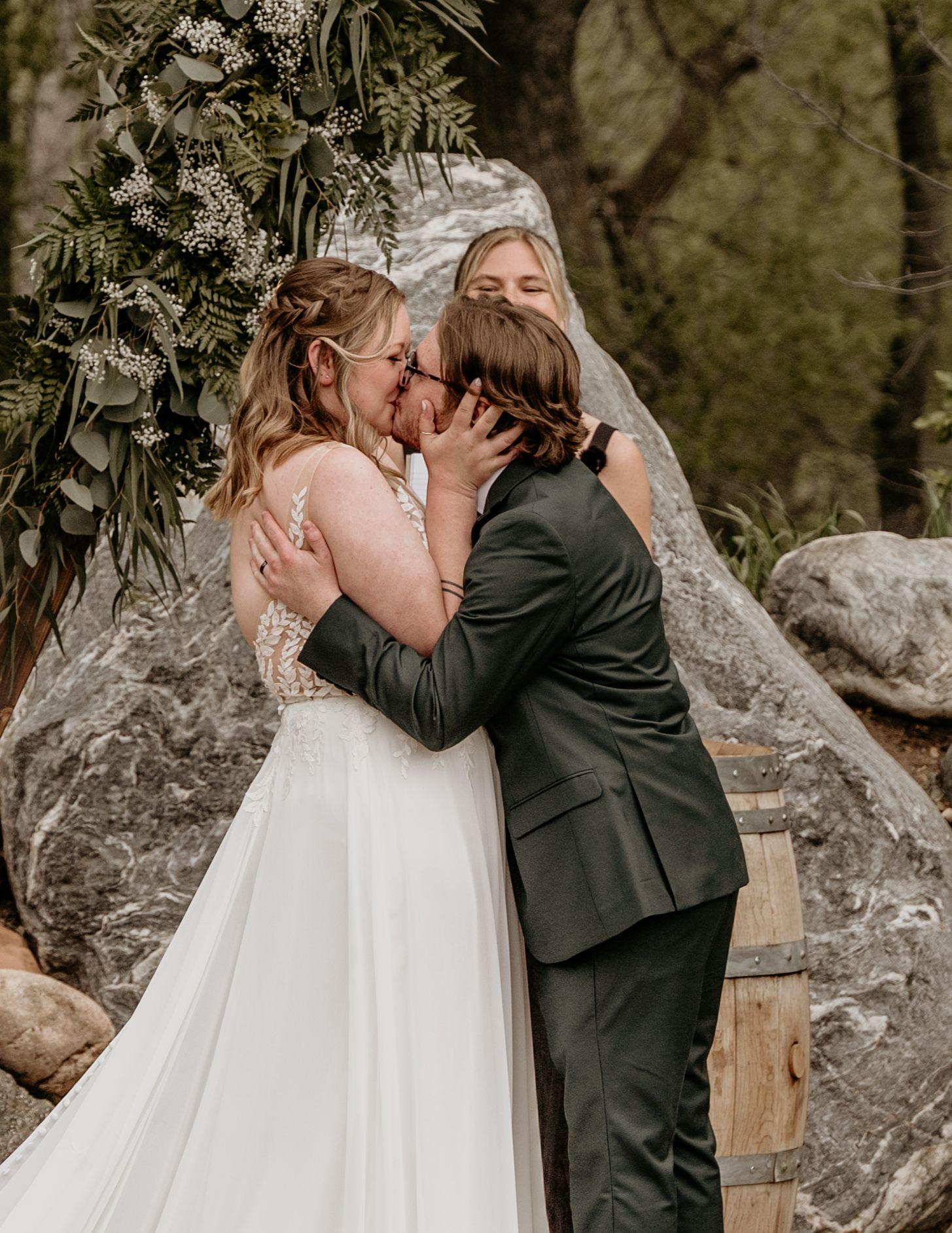 A candid first look moment in an outdoor setting with rustic buildings in the background.