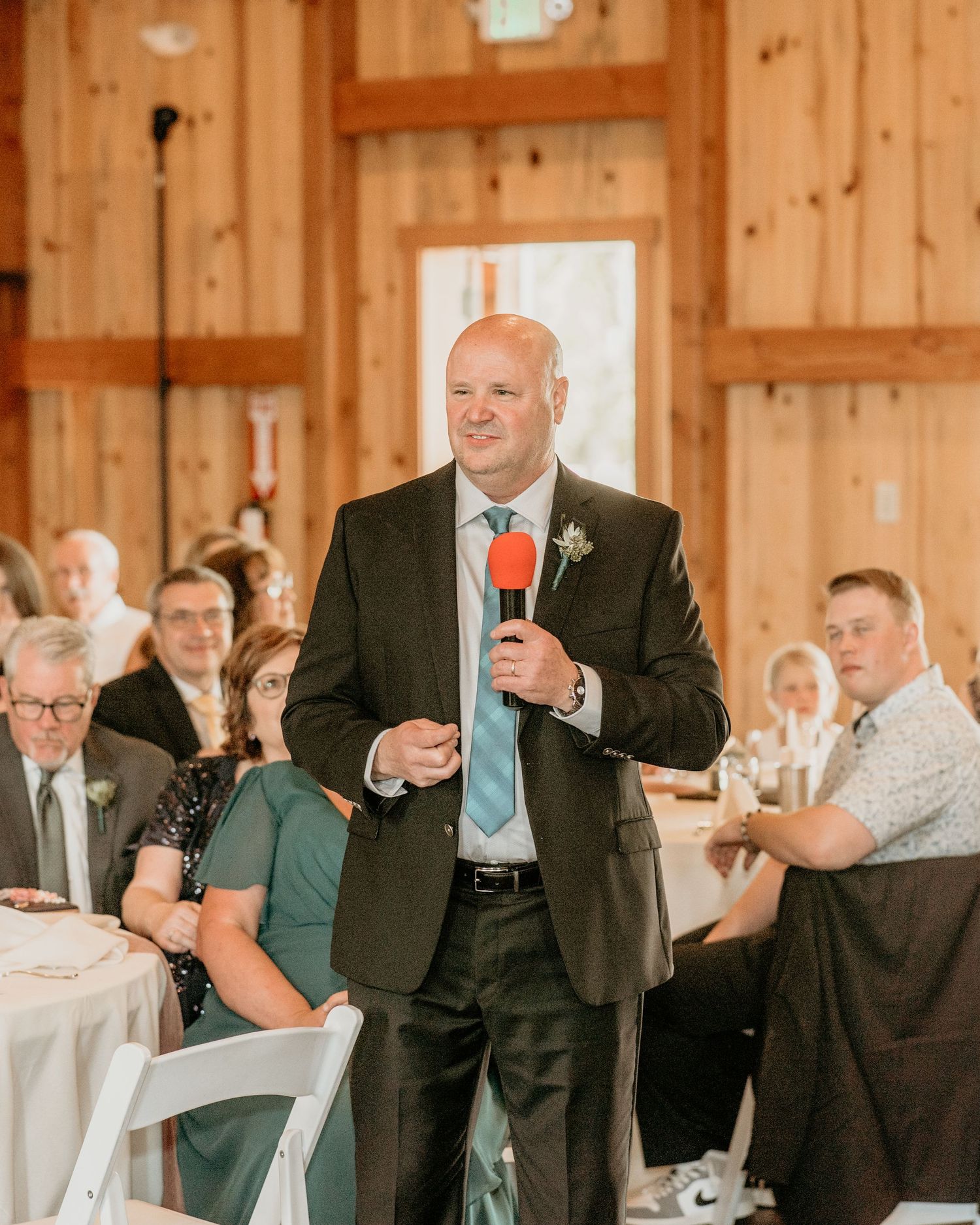 Wedding reception dance party in a rustic wooden barn with guests celebrating joyfully.