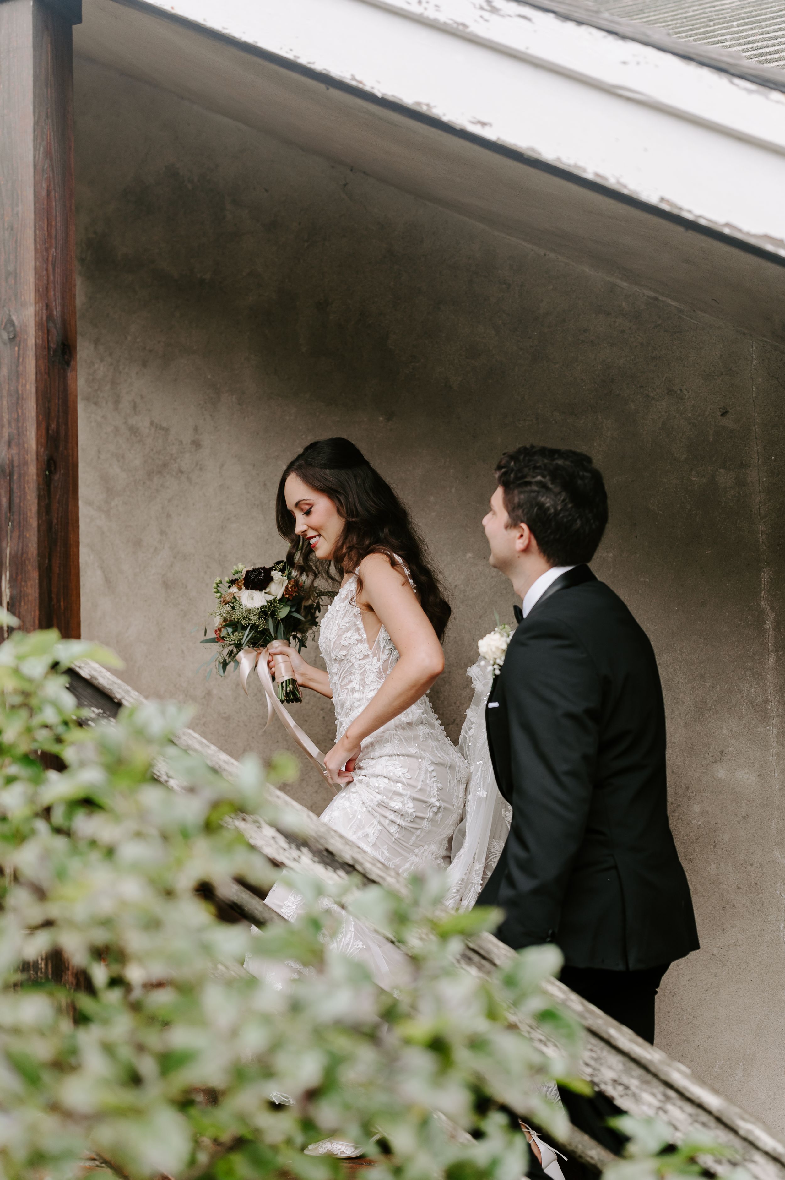 A couple shares a tender moment during their wedding photoshoot on a staircase.