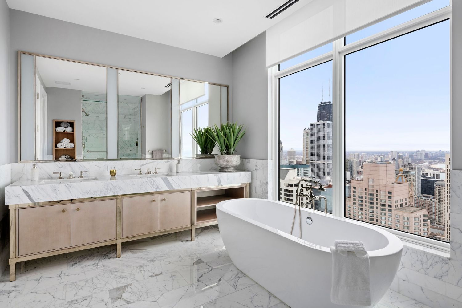 Luxury bathroom with full soaking tub in a city high rise with views of the Hancock Tower in Chicago