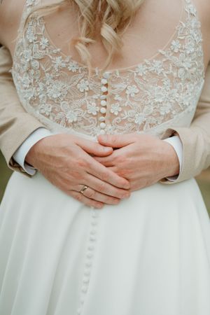 Details trouwring, handen rond bruid, foto door Lien Photography.