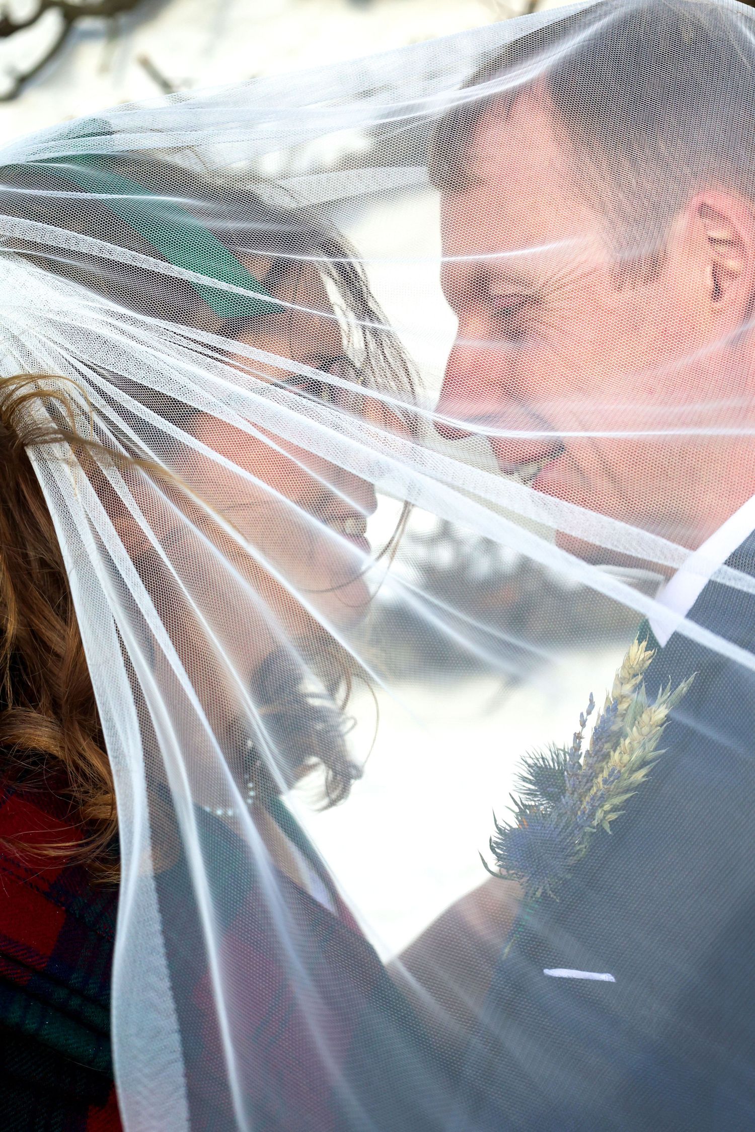 Bride and groom sharing a romantic moment under a flowing white wedding veil outdoors.R.A.M Photography, Stranraer