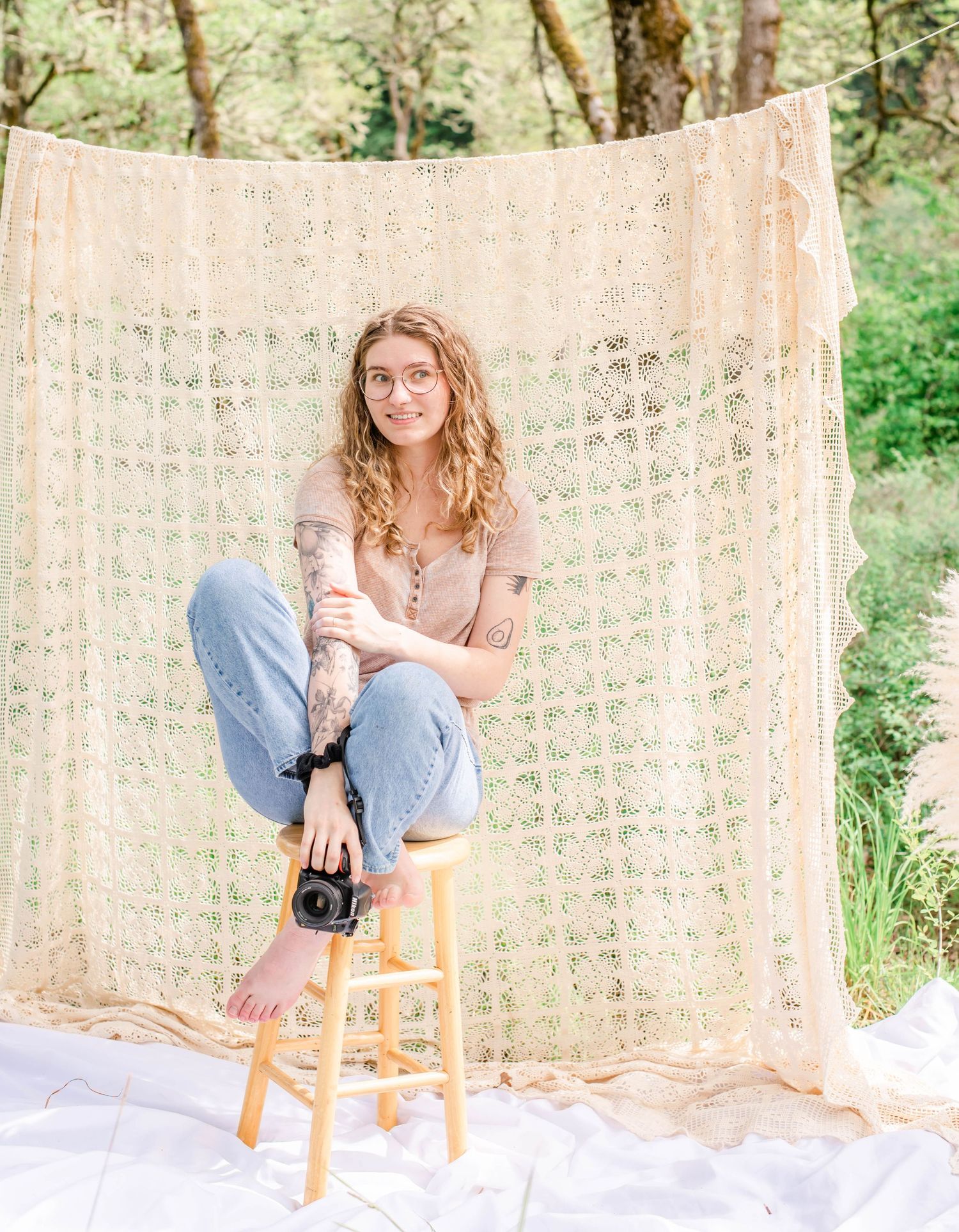 Candid photo shoot features photographer with camera against textured wall in natural light.