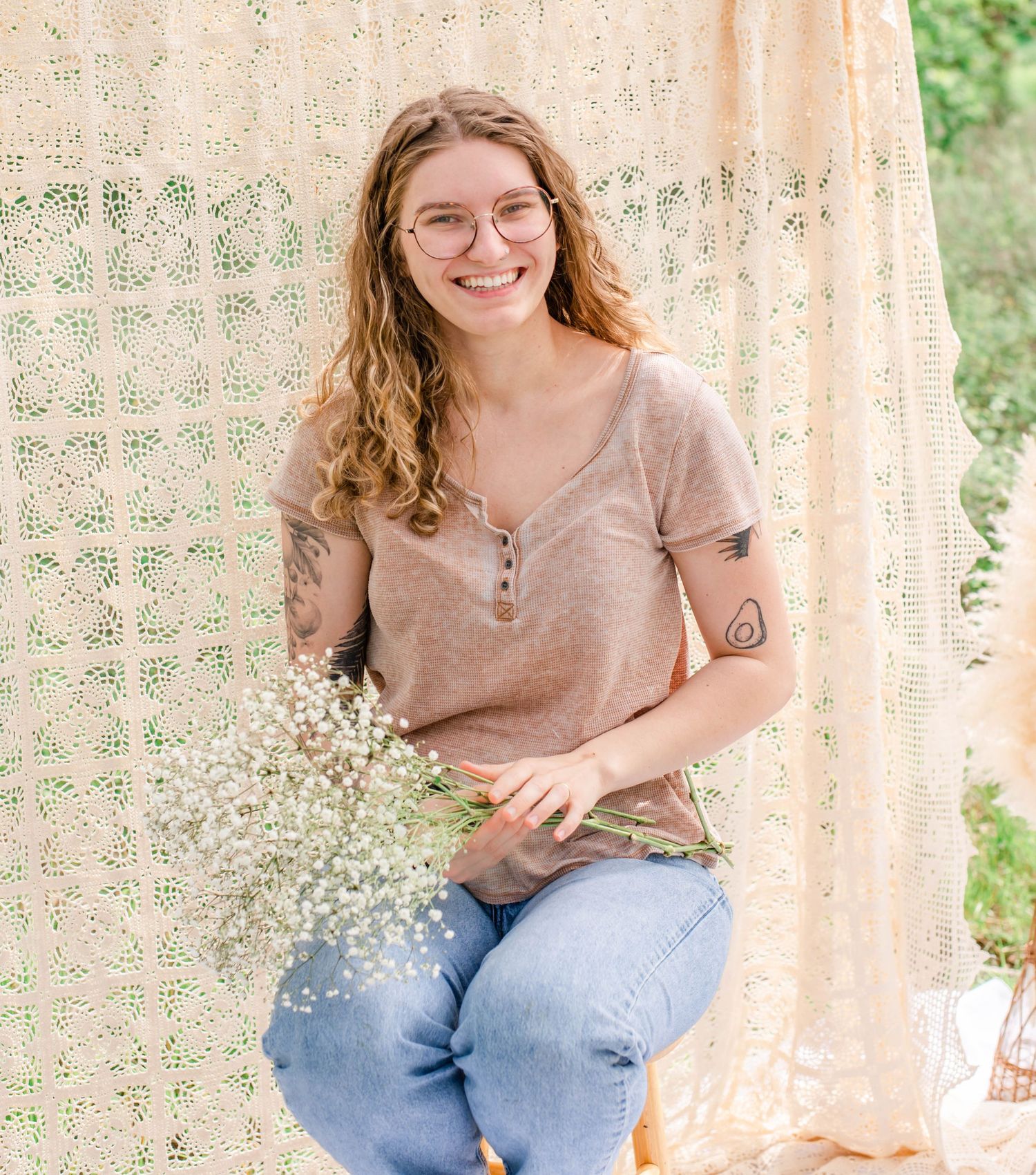 Styled portrait session featuring woman with baby's breath flowers against lace curtain.