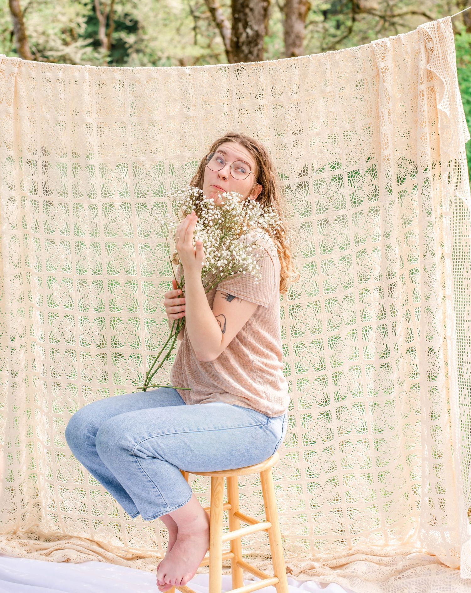Artistic portrait series with vintage lace curtain and wooden stool in natural light.
