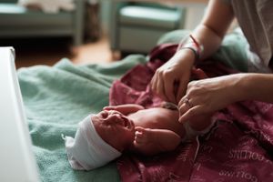 Close-up detail of tiny baby feet with pink and mint green blankets.