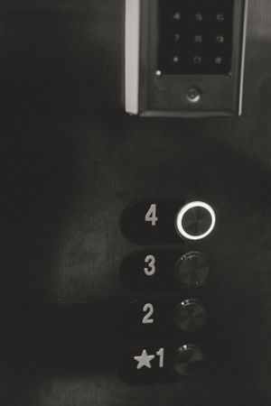 Dark elevator panel showing floor numbers and buttons.