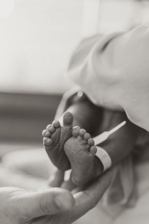 Close up black and white photo of tiny newborn baby feet.