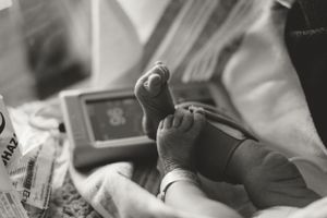Infant receiving a bottle while resting on a soft surface.