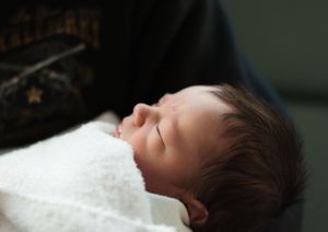 Baby sleeping peacefully in black and white portrait style.