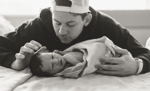 Black and white image of intimate feeding moment with baby.