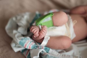 Close-up of tiny baby feet and hands during feeding time.