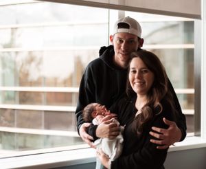 Family bonding with their newborn baby in a cozy indoor setting.
