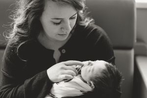 Intimate monochrome image of parent gazing lovingly at their newborn.
