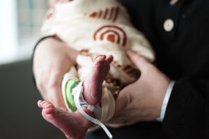 Close-up shot of tiny newborn hands being held with care and love.
