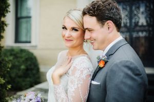 Romantic outdoor wedding portrait in front of classic architecture.