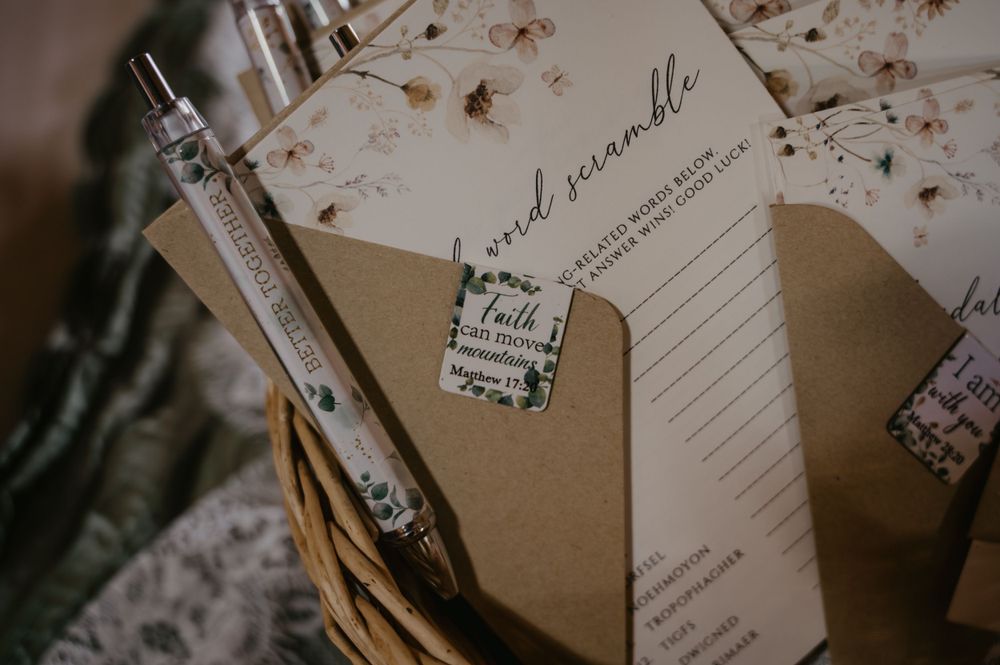 Bridal shower word scramble game cards and floral pens arranged in a wicker basket.