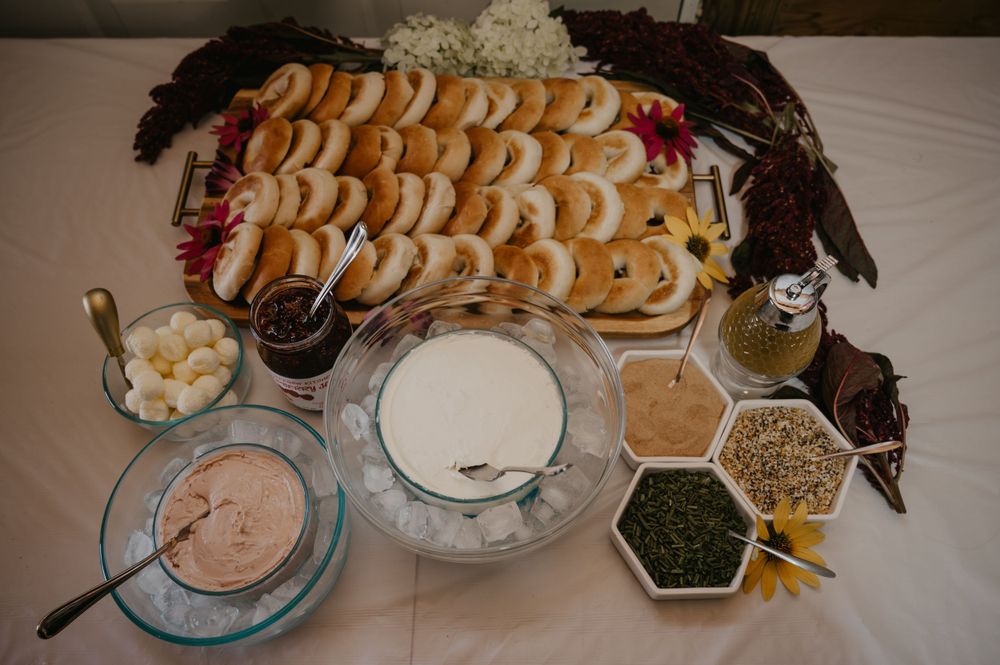 Elegant bridal shower bagel bar spread with cream cheese, toppings, and fresh garnishes.
