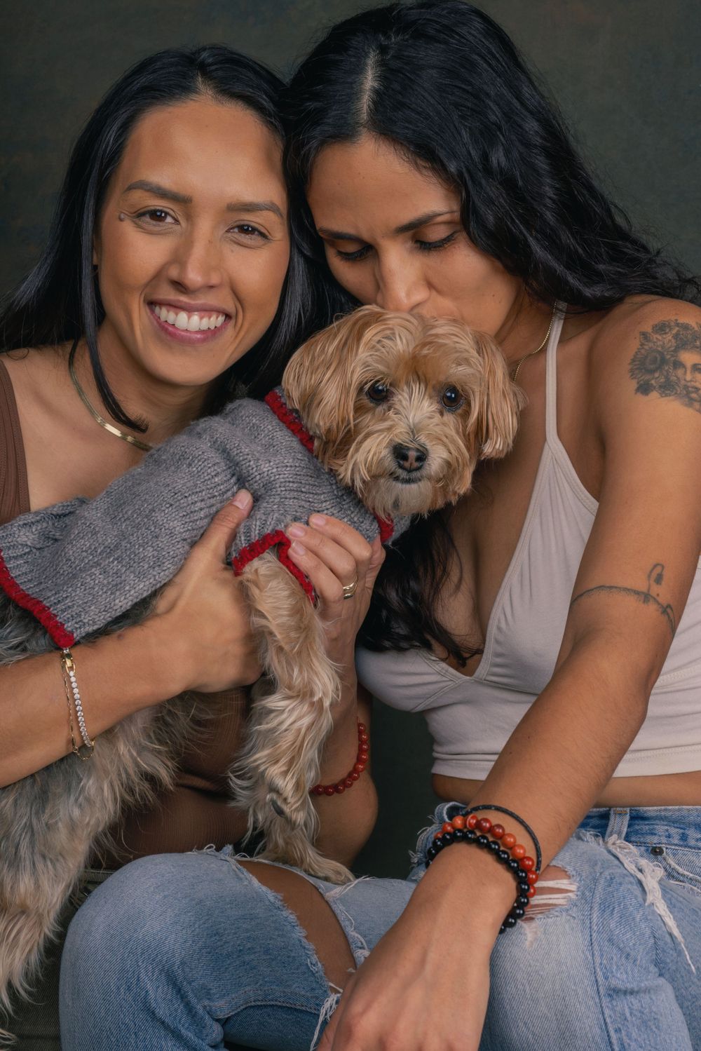Candid moments of two people cuddling with a small brown dog wearing a red collar.
