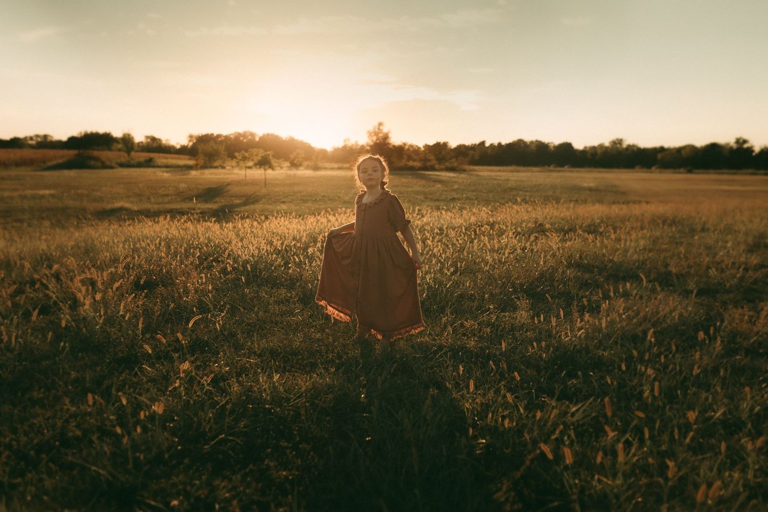 Child walking into sunset in wide open field – cinematic storytelling portrait in Kansas
