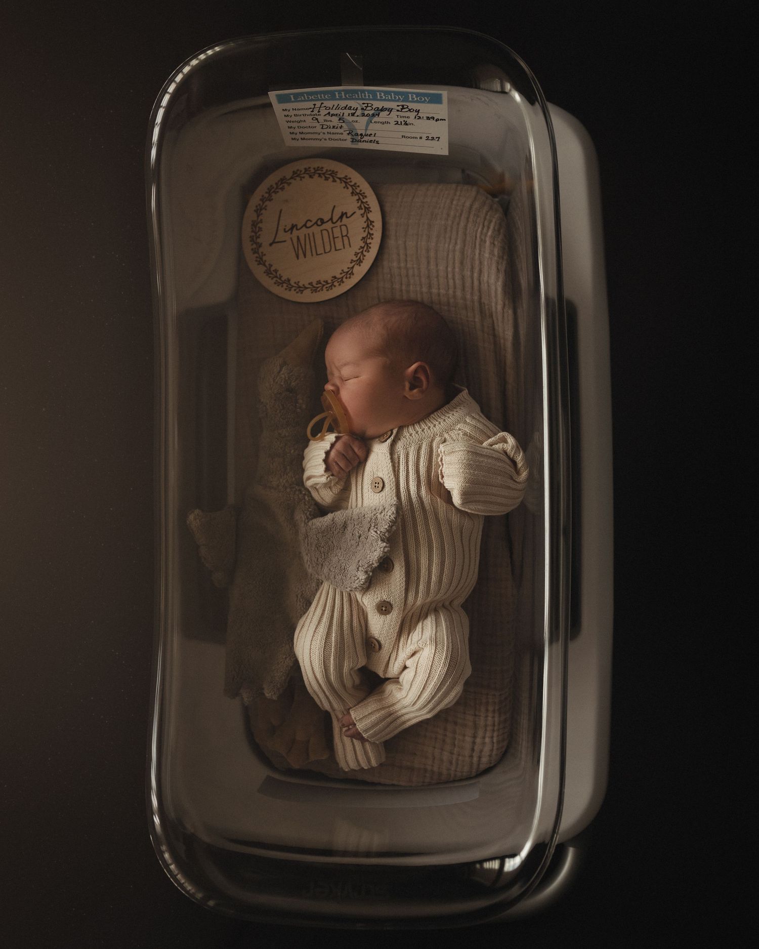 Newborn sleeping peacefully in car seat – moody and artistic baby portrait