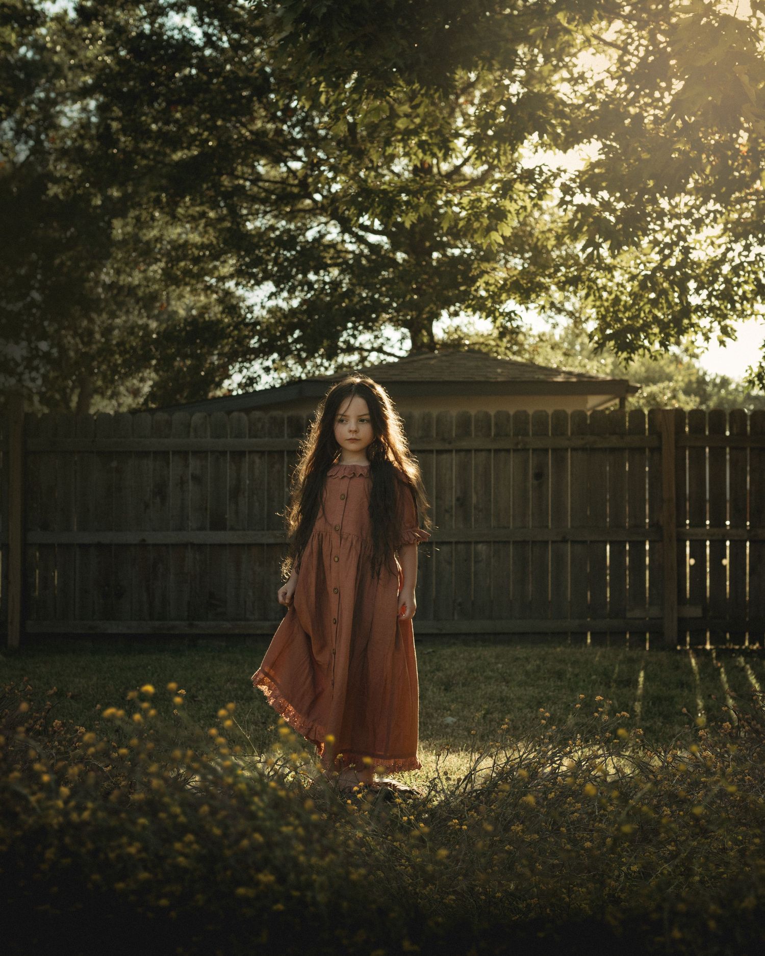 Young girl standing in backyard at sunset – nostalgic childhood photography in Kansas
