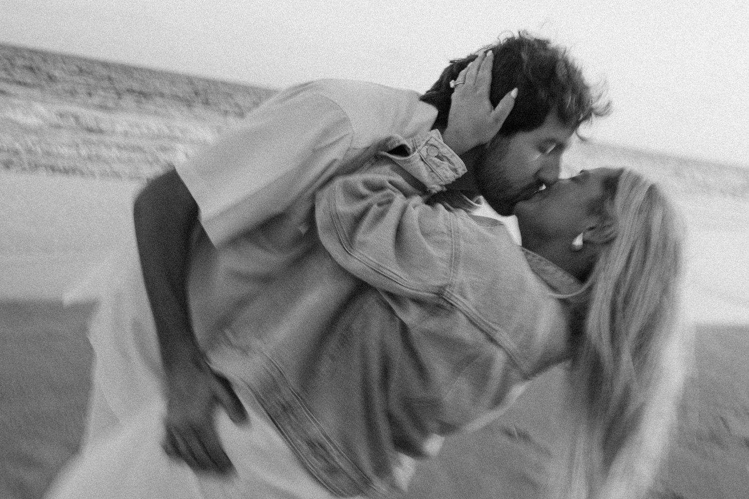A black and white romantic photograph by B. Logsdon Photography shows a couple on the beach of Hilton Head Island, SC.