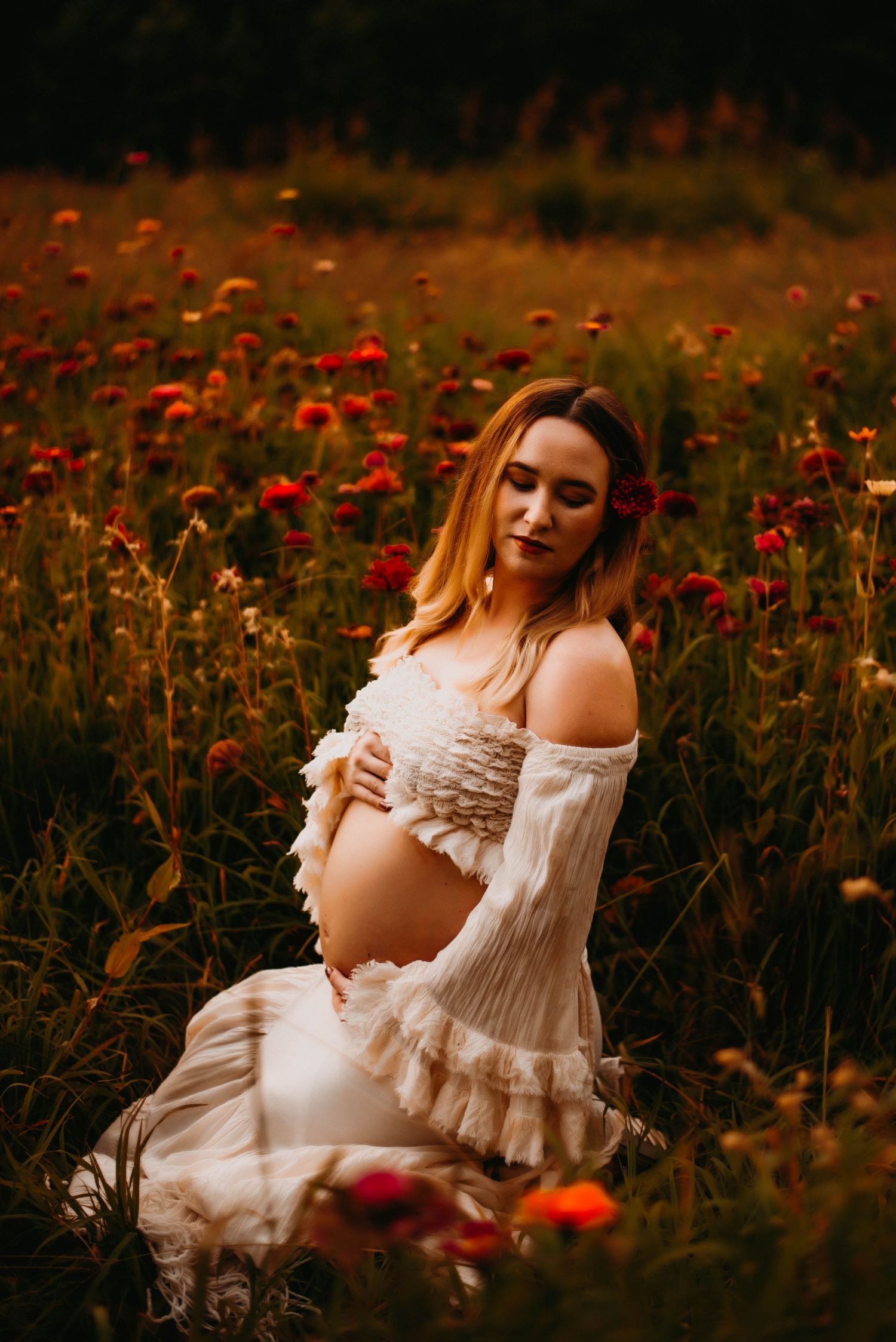 Dreamy maternity session in a field of red wildflowers with white lace dress.