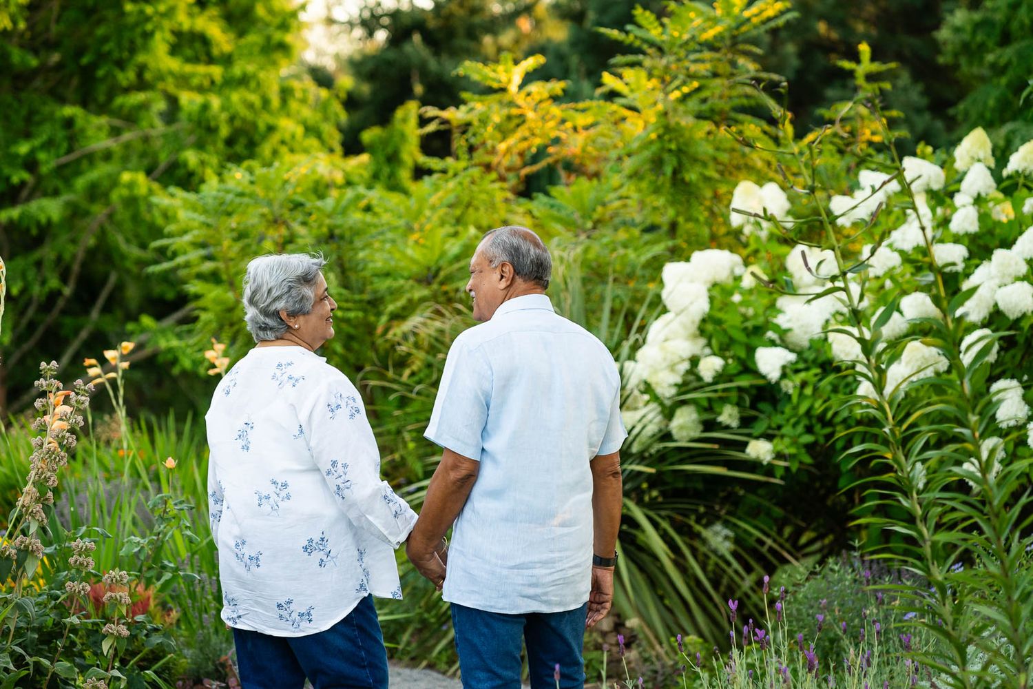 Grandparents hold hands and smile at Bellevue Botanical Garden.