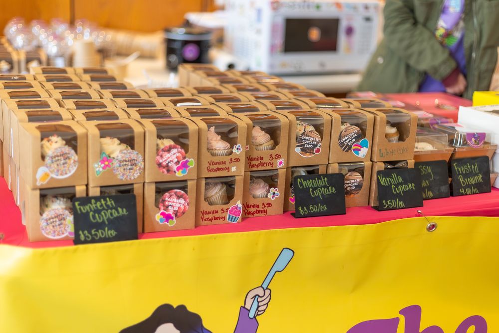 Display of wooden boxes containing specialty products on yellow retail counter.