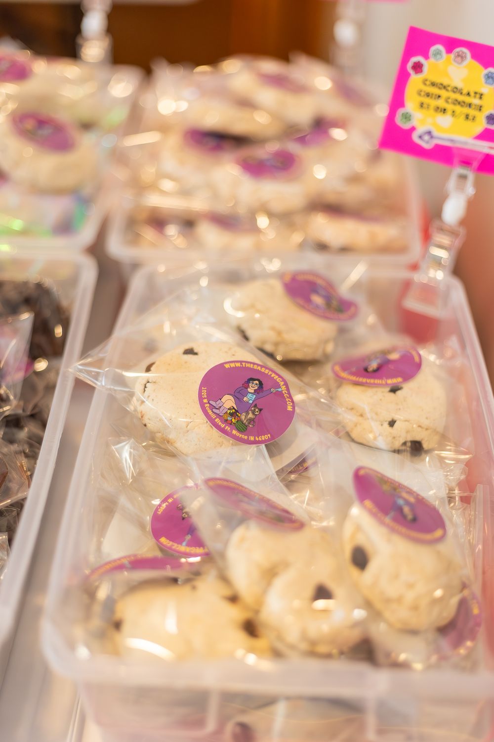 Packaged cookies with purple decorative labels displayed in retail setting.