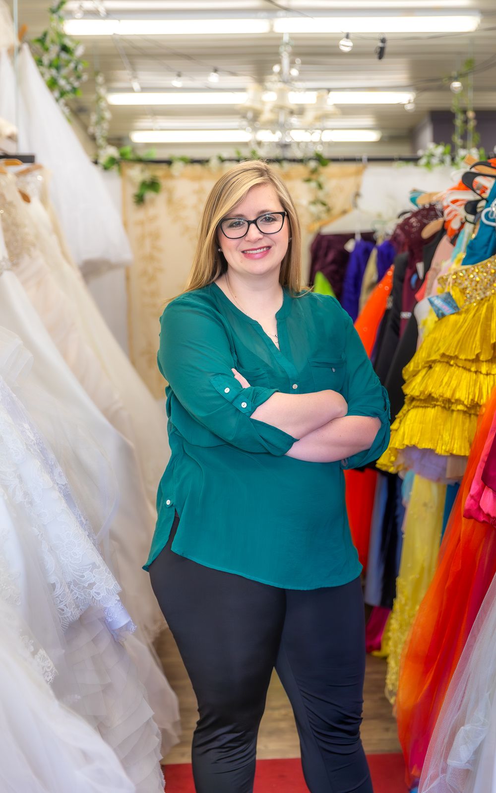 Bridal shop interior showing wedding dresses and colorful formal wear displays.