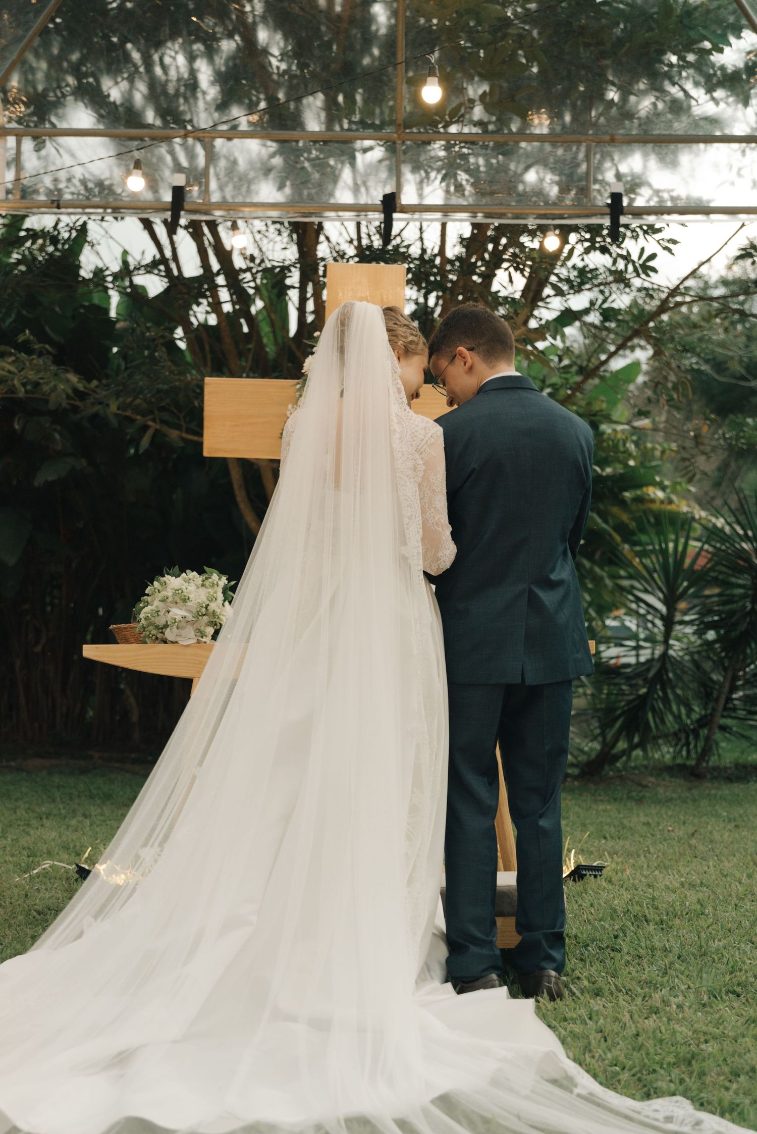 Bride and groom share an intimate moment during outdoor garden wedding ceremony.
