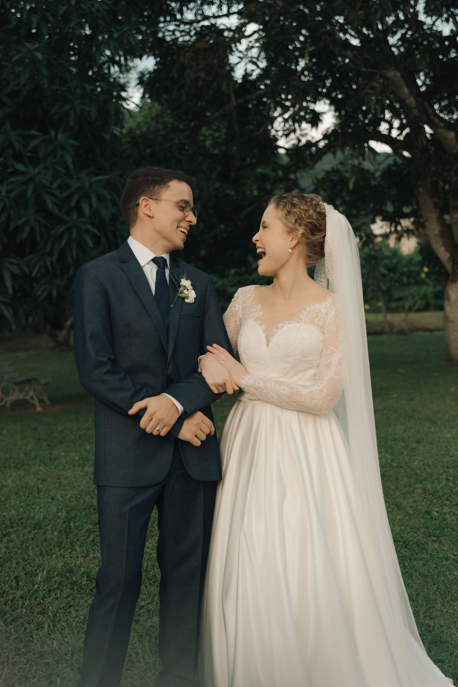Happy newlyweds share laughter during outdoor wedding portraits.