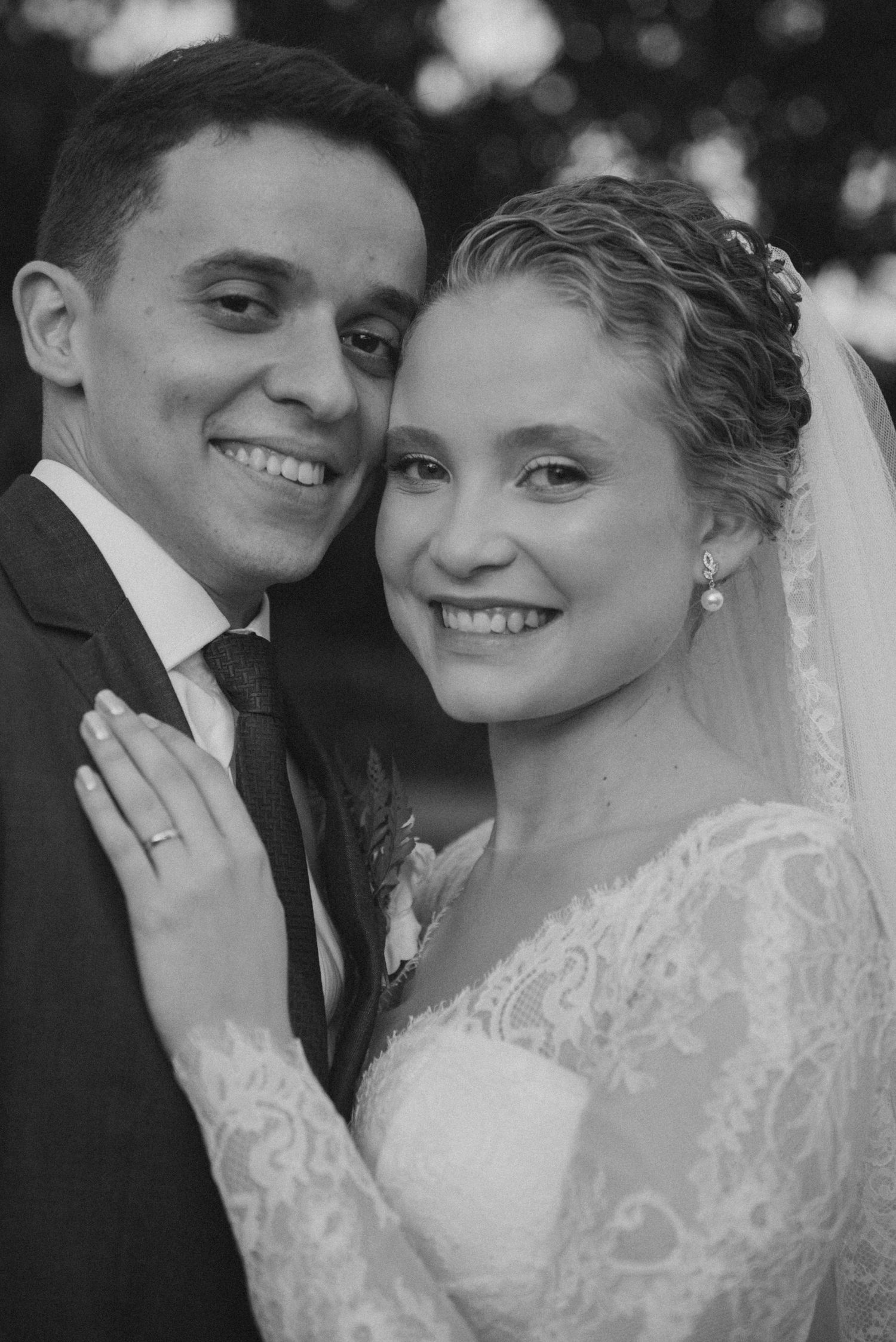 Black and white portrait of newlyweds smiling together outdoors.