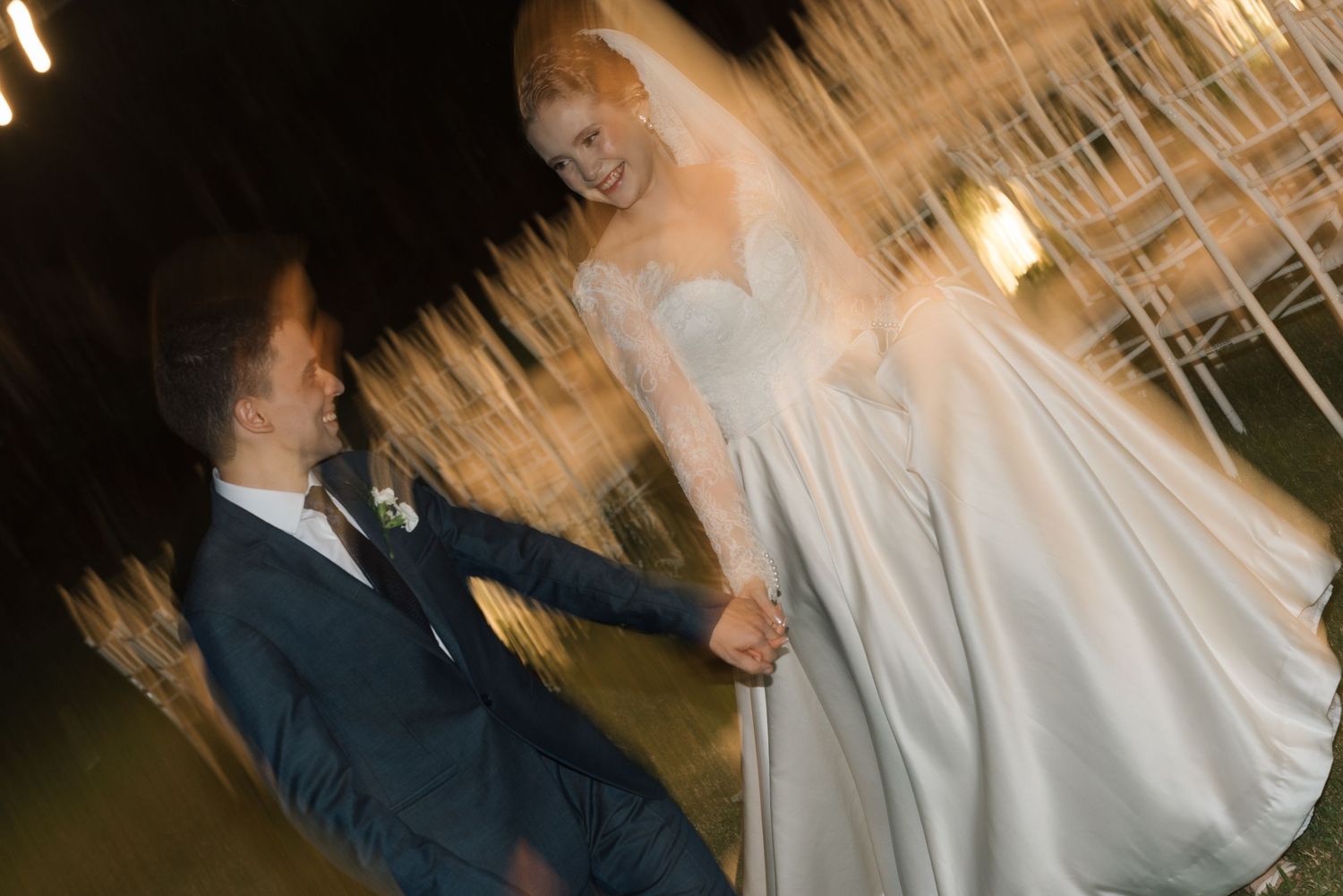 Artistic motion-blur capture of wedding couple's first dance outdoors.