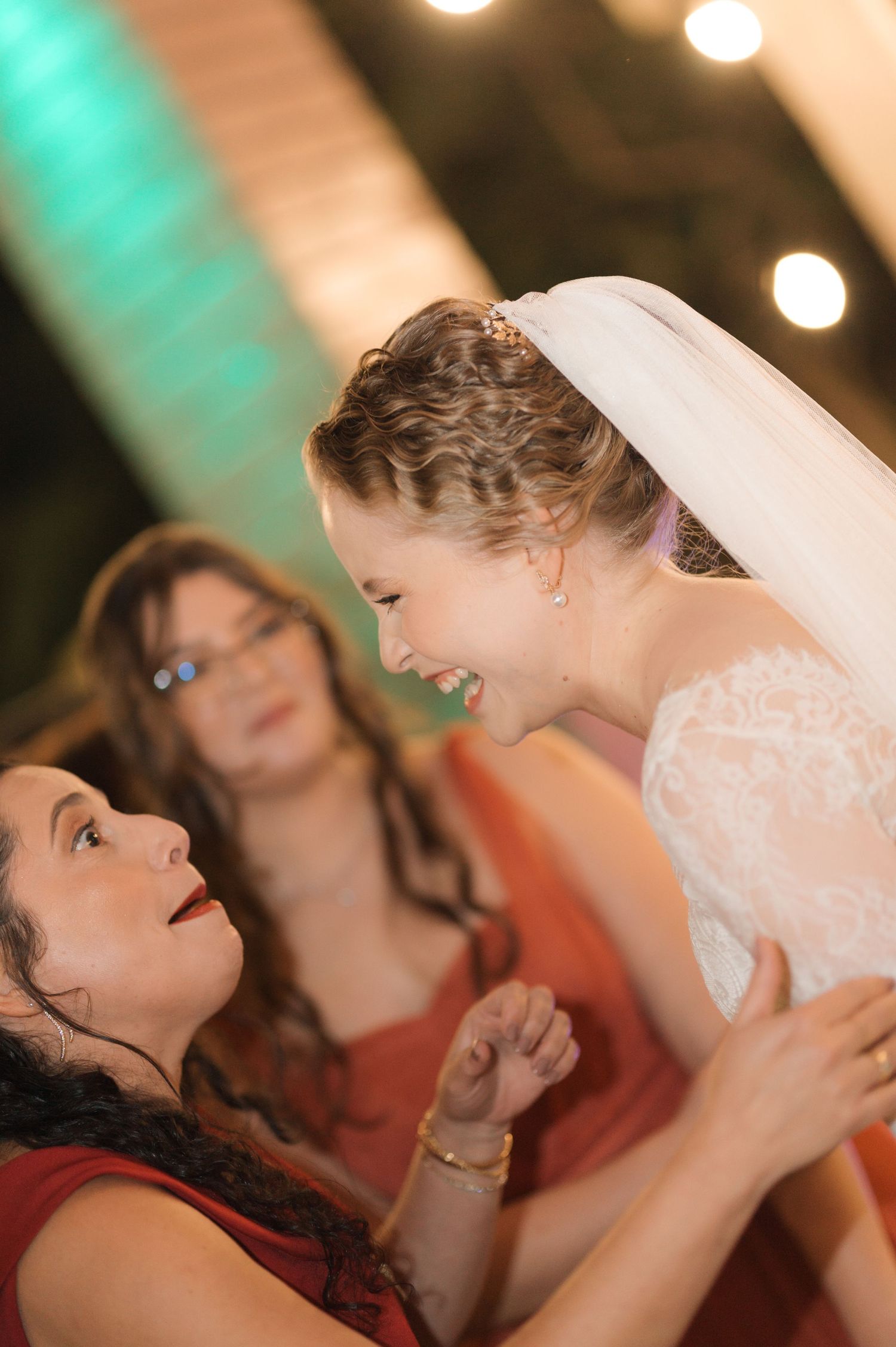 A joyful candid moment between wedding guests during the celebration.