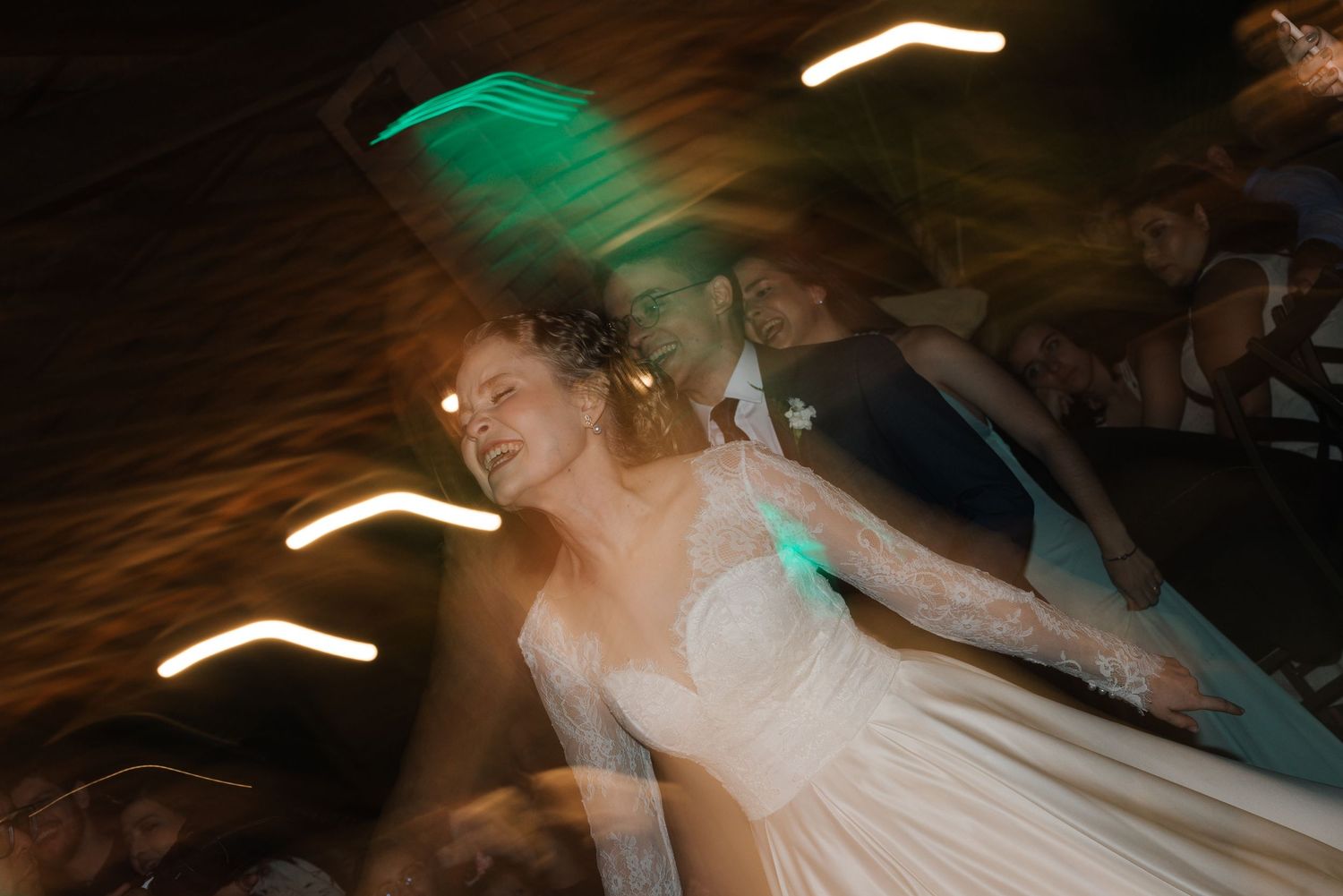 An artistic wedding photo with teal lighting and motion blur creating a dreamy atmosphere.
