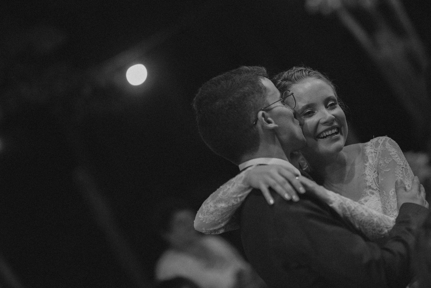 Tender dance moment captured in black and white under evening sky.