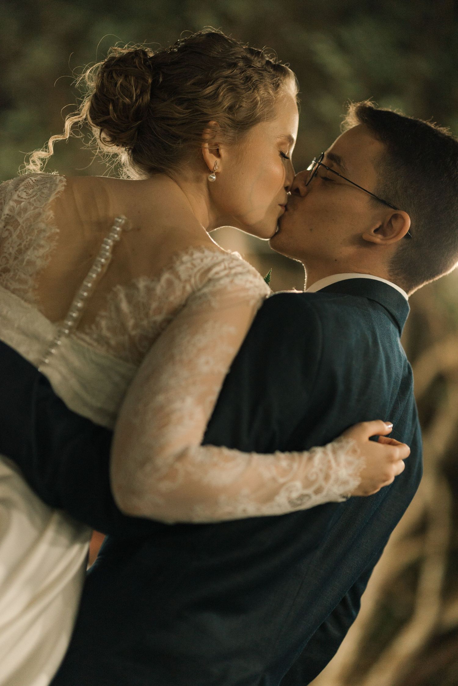 A romantic wedding moment captured in warm lighting during an evening celebration.