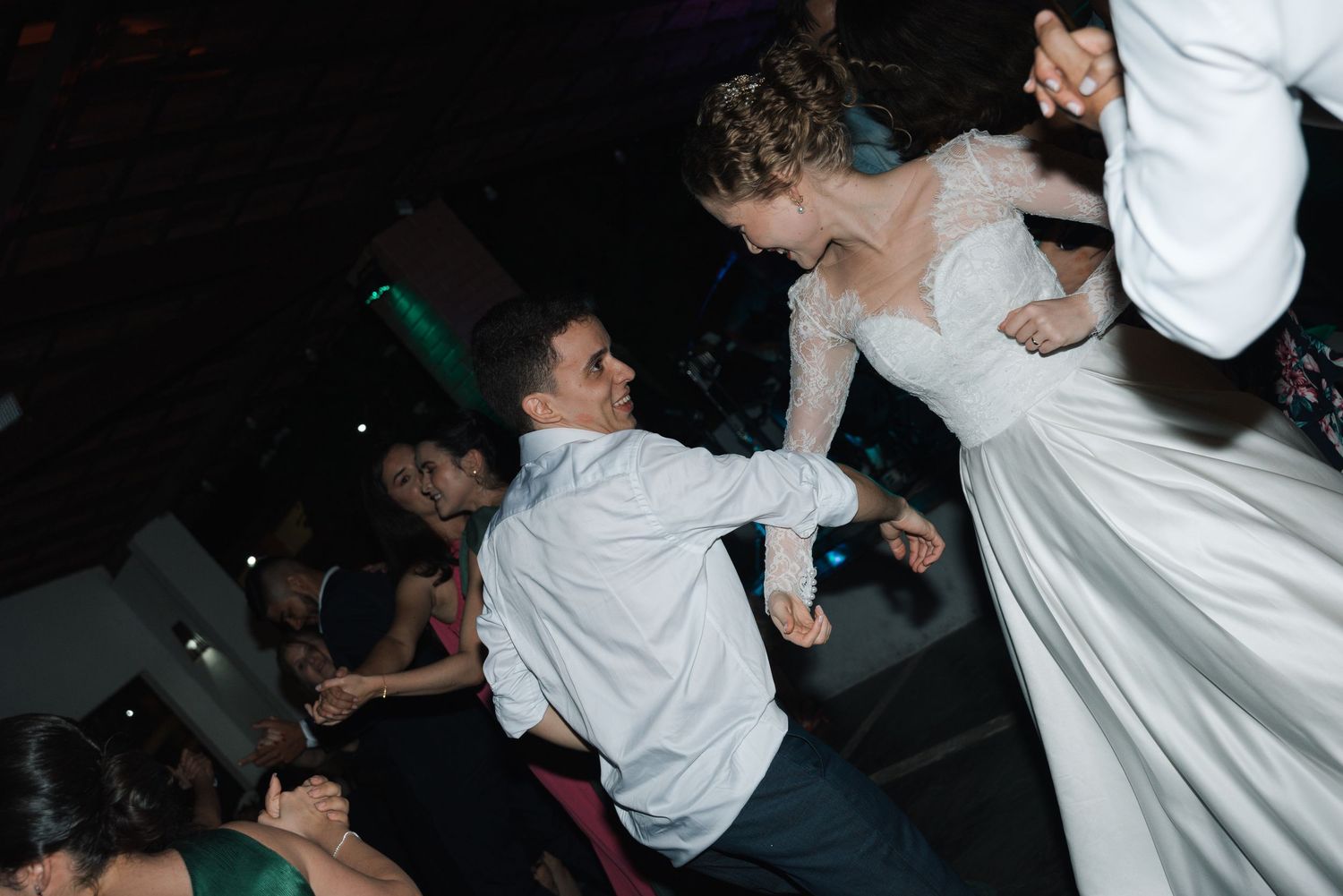 Wedding guests dancing and twirling energetically during reception celebrations.