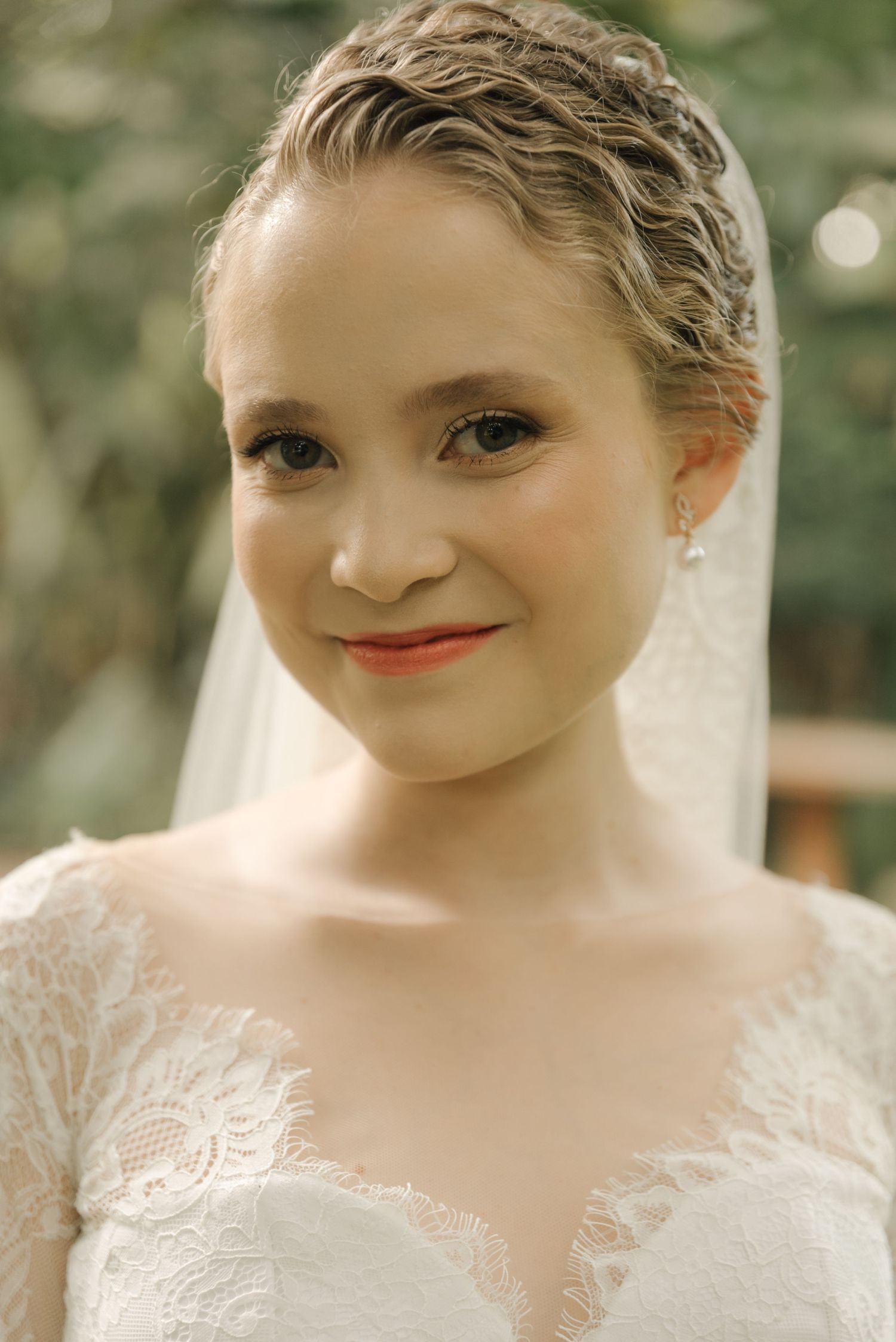 Portrait of a bride wearing a delicate lace wedding dress and veil.