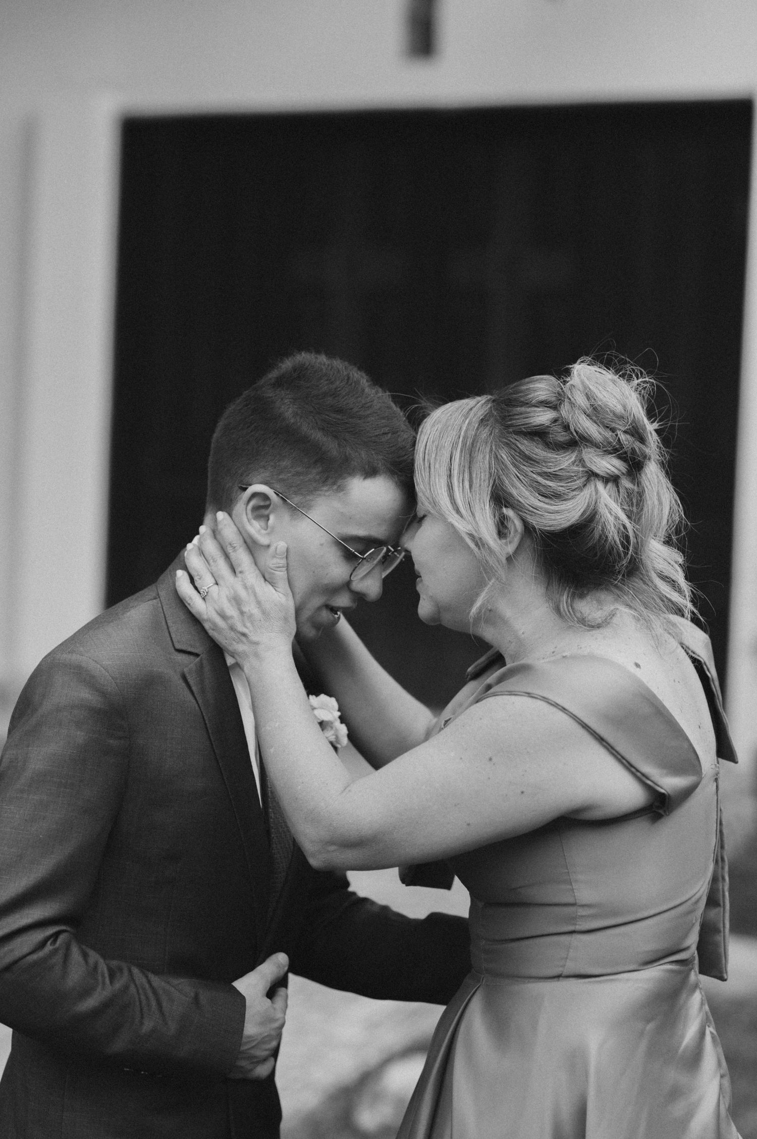 Intimate black and white moment between wedding couple sharing an emotional embrace.