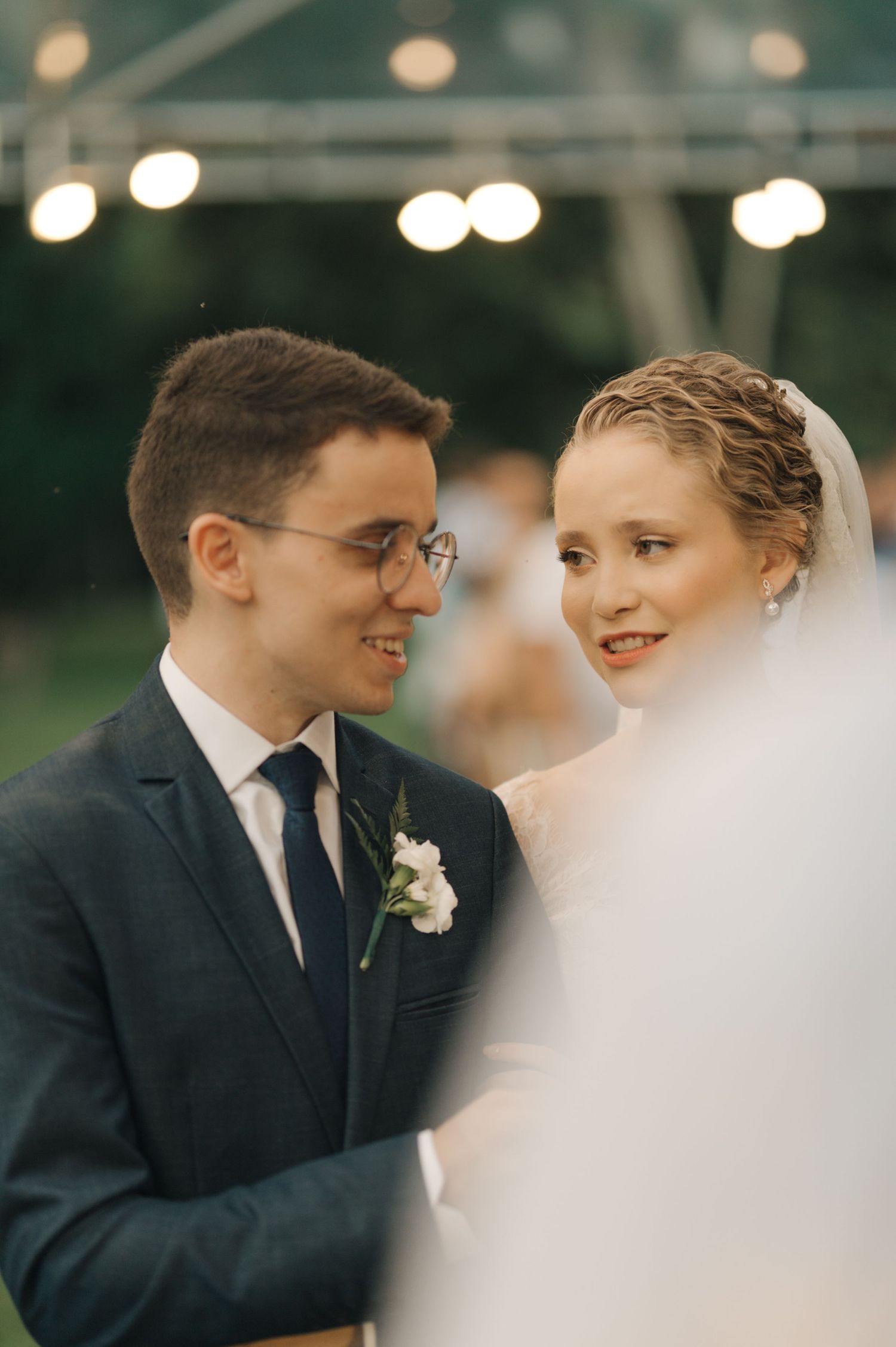 Couple shares a tender moment during their outdoor evening wedding ceremony.