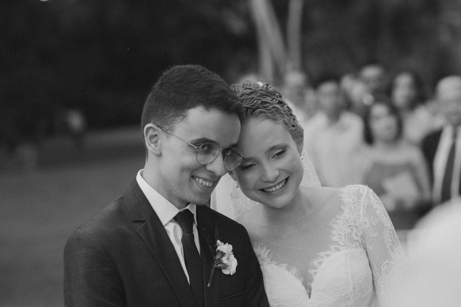 Black and white portrait of a happy couple sharing an intimate moment at their outdoor wedding.