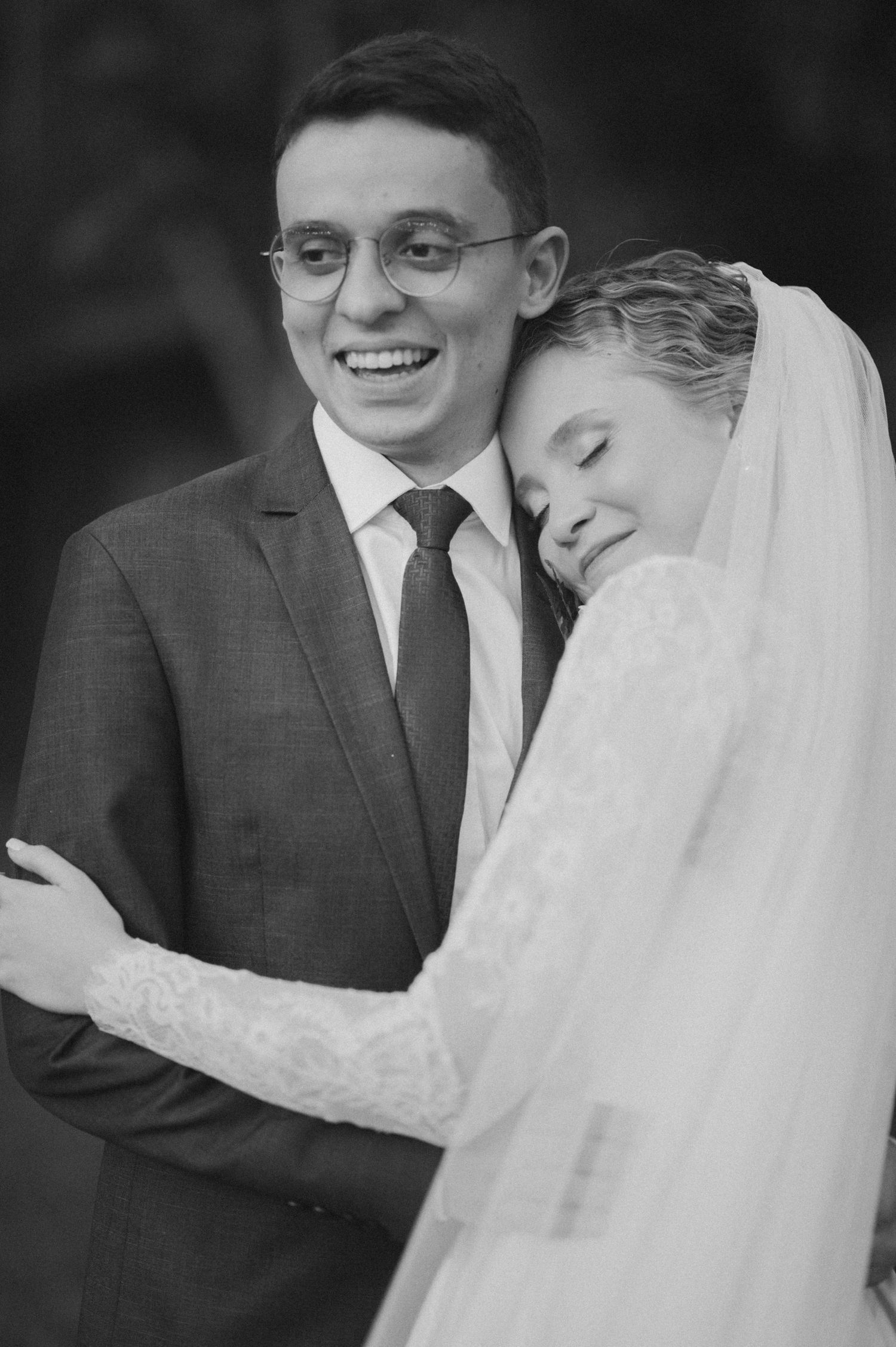 Black and white portrait of tender embrace between newlyweds.