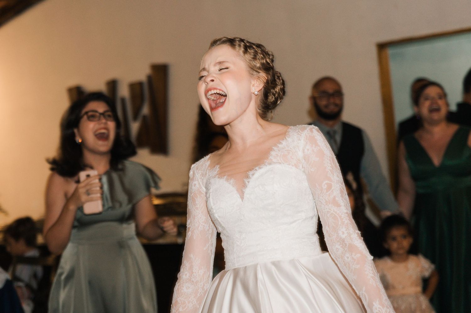 A bride in a classic white gown shares a joyful moment during her wedding reception.