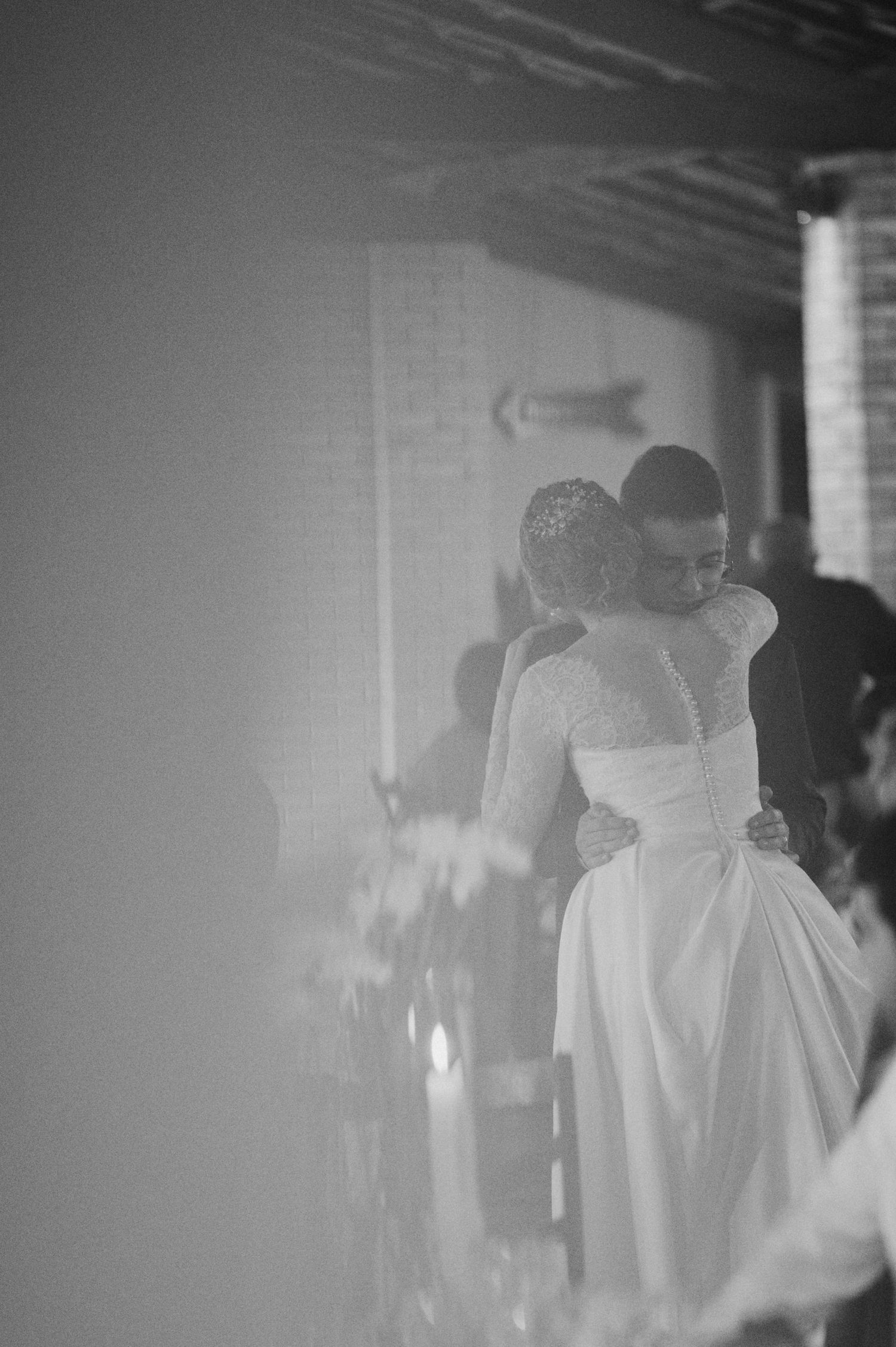 A tender embrace during a wedding dance captured in black and white photography.